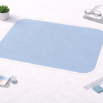 A clean desktop scene centers on a large blue workspace mat surrounded by neatly arranged office items like a coffee cup, plant, notebooks, ruler, and sticky notes.